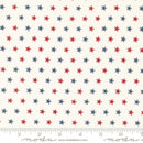 Wide quilt backing fabric with a pattern of red and blue stars on an off white background with a ruler at the bottom to show scale.