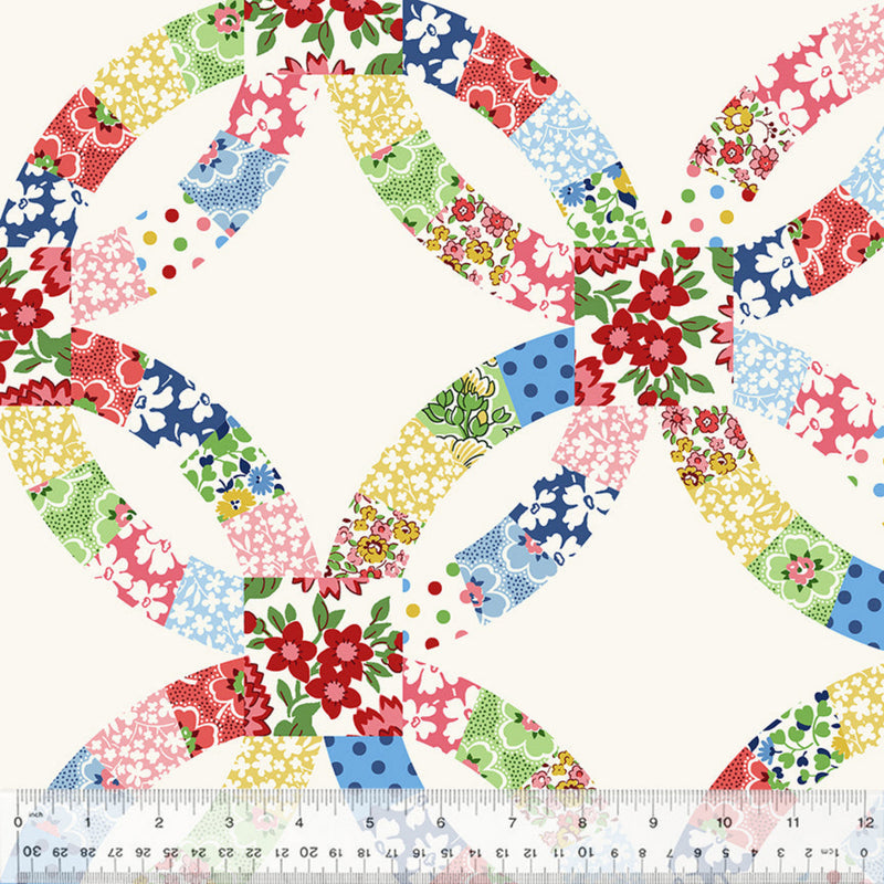 Colorful floral patterned fabric in the double wedding ring design with a ruler at the bottom