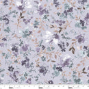 Floral patterned wide quilt backing fabric  with purple flowers on a dusty lavender background with a ruler at the bottom to show scale.