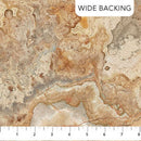 Wide quilt backing fabric with a stone and agate-like print in brown and beige with a ruler at the bottom to show scale.