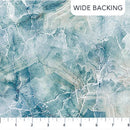 Wide quilt backing fabric with a marble-like pattern in blue and gray tones with a ruler at the bottom for scale.