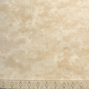 Tan wide quilt backing fabric in a mottled tone on tone print with a ruler at the bottom to show scale.