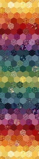 A full width image of wide quilt backing fabric with a pattern made of many hexagonal patches in a rainbow gradient, transitioning from yellow and orange at the top through red, purple, blue, and green to warm tones at the bottom.