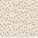 Wide quilt backing fabric with small blue and red starbursts with dotted trails on a beige background with a ruler at the bottom to show scale.