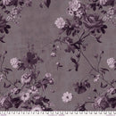 Wide quilt backing fabric with a floral pattern with purple and white flowers on a gray background and a ruler at the bottom to show scale.