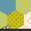 Wide quilt backing fabric with a colorful hexagonal pattern with various shapes and colors with a ruler at the bottom to show scale.