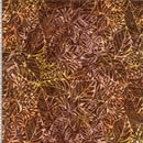Batik wide quilt backing fabric in shades of brown, tan, yellow and peach with an allover leaf pattern and a ruler on the side to show scale.